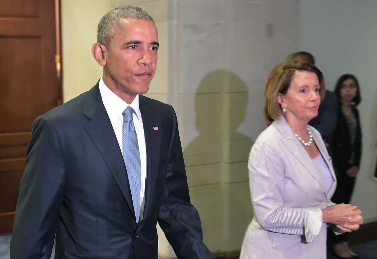 US President Barack Obama and House Minority Leader Nancy Pelossi walk through a hallway after meeting with House Democrats at the US Capitol on June 12, 2015 in Washington, DC. President Barack Obama Friday went to Congress Friday for a frantic round of lobbying ahead of a crucial vote on his sweeping trans-Pacific trade agenda. The House of Representatives is expected to vote mid-day Friday on final passage of so-called Trade Promotion Authority, and while Republican leaders are confident they have the momentum to get it across the finish line, the vote remains a toss-up. AFP PHOTO/MANDEL NGANMANDEL NGAN/AFP/Getty Images