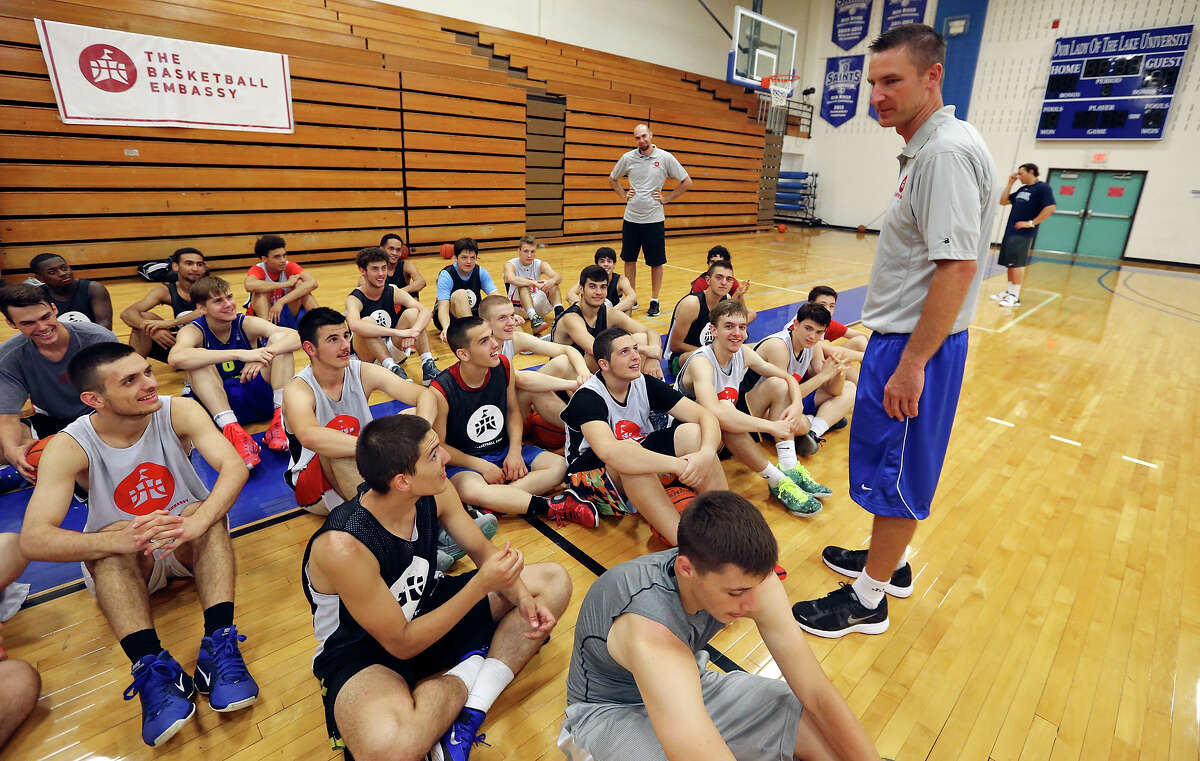 Chris Dial, executive director of The Basketball Embassy, (right) talks with players during The Basketball Embassy's inaugural Assembly 2015 camp Thursday June 18, 2015 at Our Lady of the Lake University's Mabee Gym.