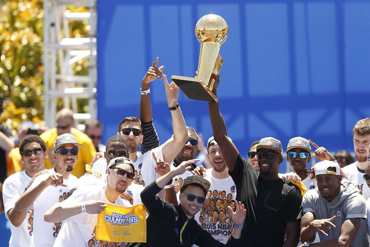 Golden State Warriors' Draymond Green hoists the trophy during the NBA Champions rally at the Henry J. Kaiser Convention Center on Friday, June 19, 2015 in Oakland, Calif.