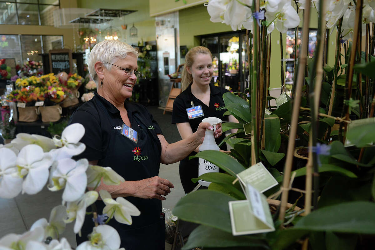 Florists Martha Walquist, left, of Spring, and Tristan Jeter, of Huntsville, water a display of carnations at the HEB store at 26500 Kuykendahl Rd. in The Woodlands. (Photo by Jerry Baker/Freelance)