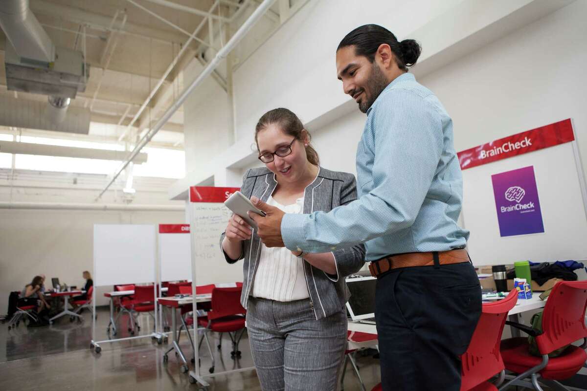 Yael Katz, left, the CEO of BrainCheck and Benjamin Flores, right, work at their station in the TMCX offices in Houston, TX on Thursday, May 28, 2015.