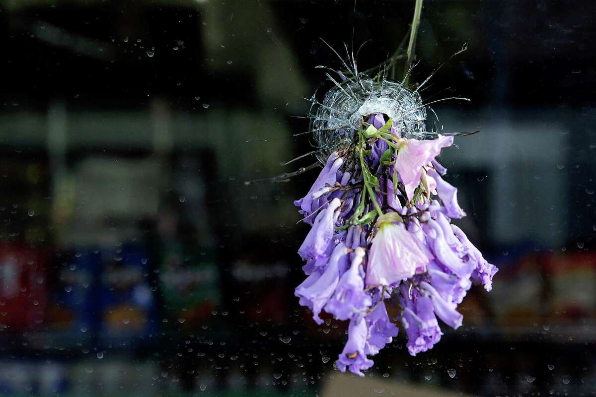Flowers are placed in a bullet hole on a window of IV Deli Mart, after a mass shooting took place by a drive-by shooter near the UC Santa Barbara campus in 2014. Some of the victims were stabbed and others were shot.