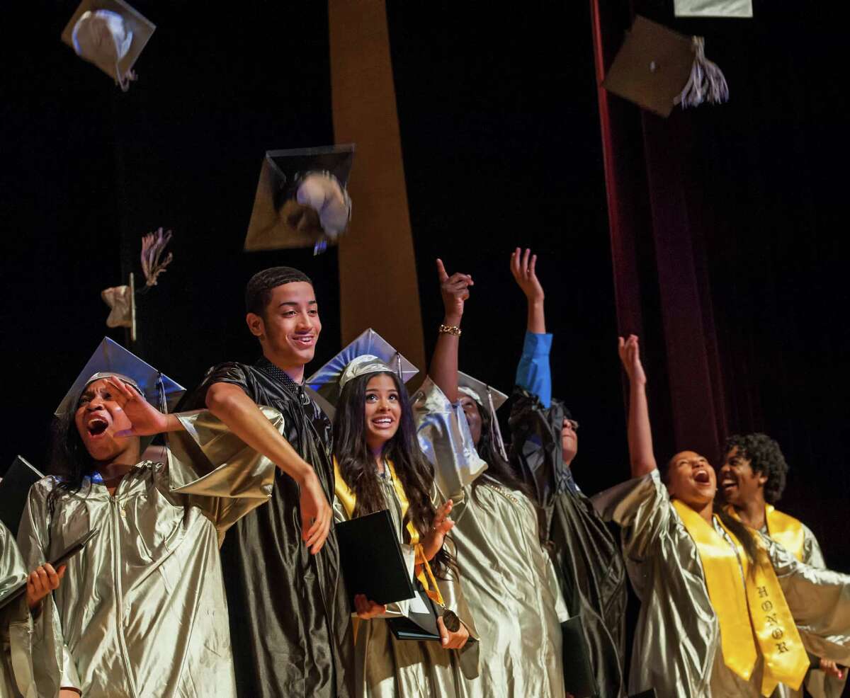 Students from The Bridge Academy toss their caps into the air at the end of the eighteenth annual commencement ceremony held at the Thurgood Marshall Middle School, Bridgeport, CT on Friday, June 19, 2015.