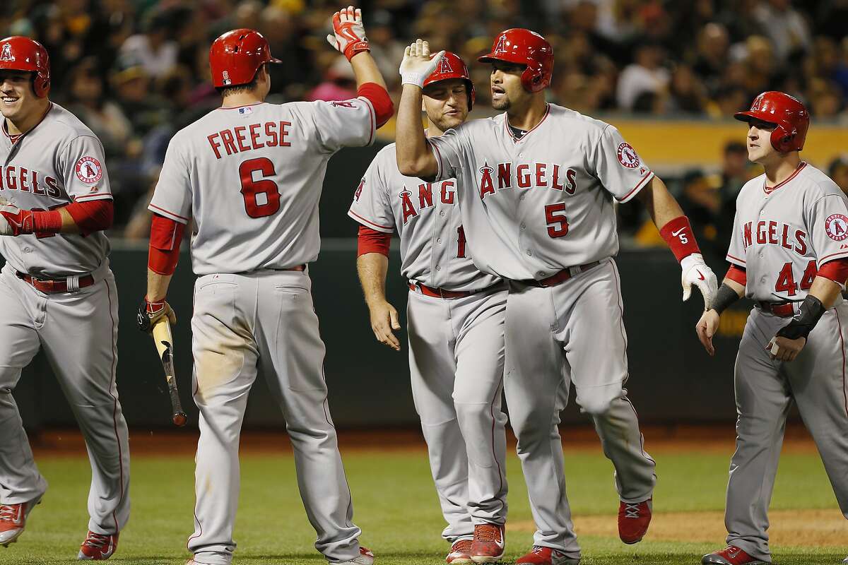 OAKLAND, CA - JUNE 19: Albert Pujols #5 of the Los Angeles Angels of Anaheim celebrates hitting a grand slam with Mike Trout #27, Daniel Robertson #44, and David Freese #6 against the Oakland A's in the seventh inning at O.co Coliseum on June 19, 2015 in Oakland, California. The Angels took the lead with the slam and are ahead 10-7 in the ninth inning. (Photo by Brian Bahr/Getty Images)