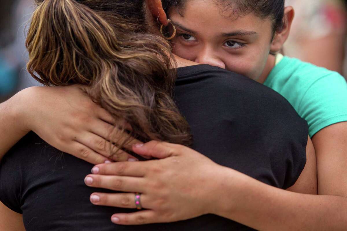 Cesilia Ovalle, right, gives her mom Lesby Esquivel a hug during a Domesticas Unidas protest on the sidewalk in front of Central Market on Broadway Avenue in San Antonio, Texas. "Because of her, I can grow up to be something that she never could be," she said. Ray Whitehouse / San Antonio Express-News