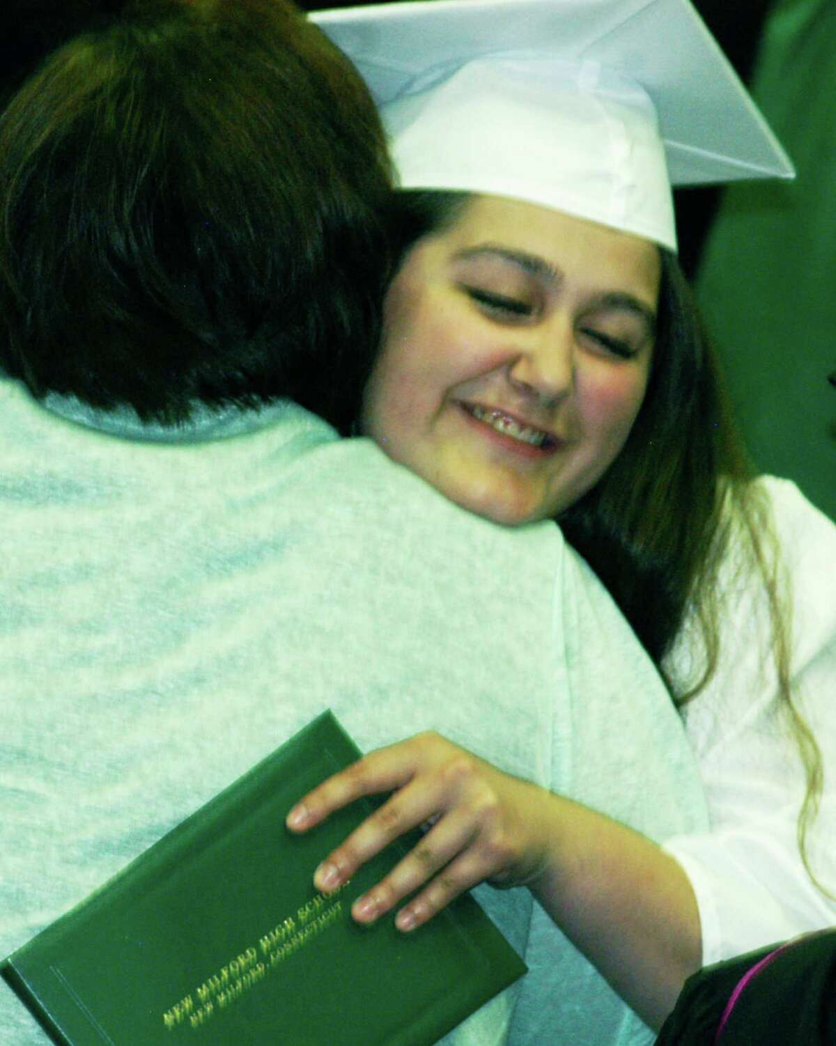 Amber Levine shares an emotional enmbrace Saturday with Class of 2015 advisor Daisy Norlander moments after receiving her diploma during the New Milford High School commencement ceremony at the O'Neill Center on the campus of Western Connecticut State University in Danbury. June 20, 2015