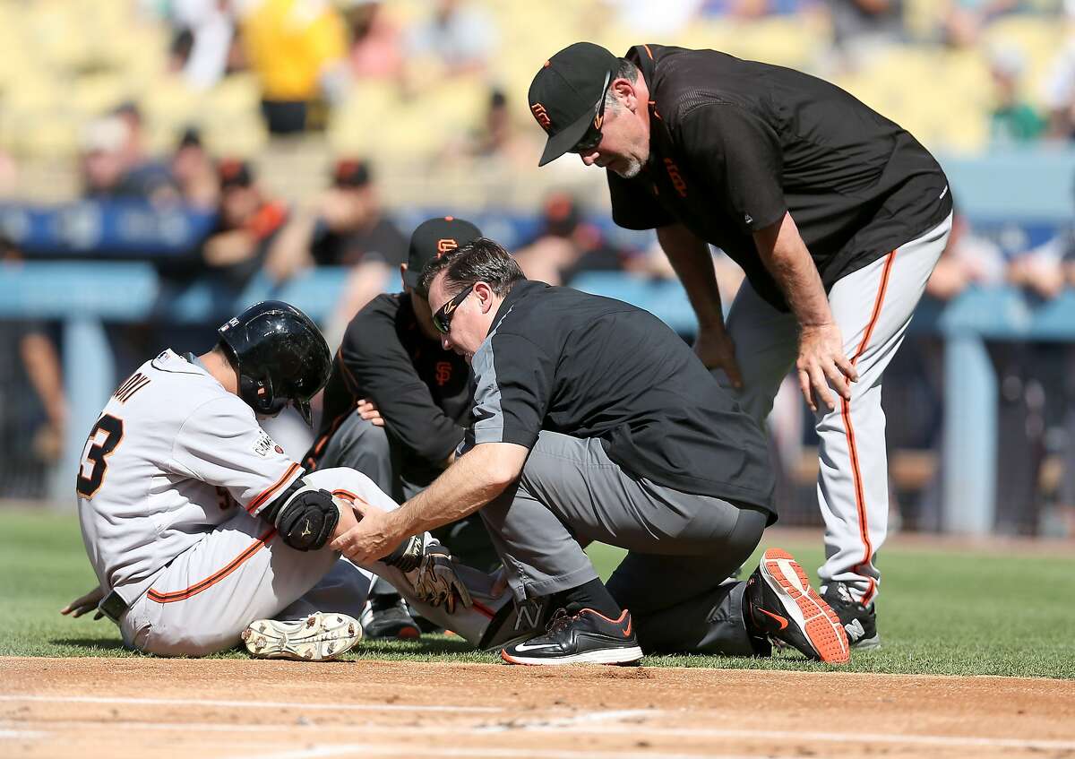 LOS ANGELES, CA - JUNE 20: Nori Aoki #23 of the San Francisco Giants is tended to by Giants' trainers as manager Bruce Bochy (R) looks on after Aoki was hit in the ankle by a pitch in the first inning against the Los Angeles Dodgers at Dodger Stadium on June 20, 2015 in Los Angeles, California. (Photo by Stephen Dunn/Getty Images)