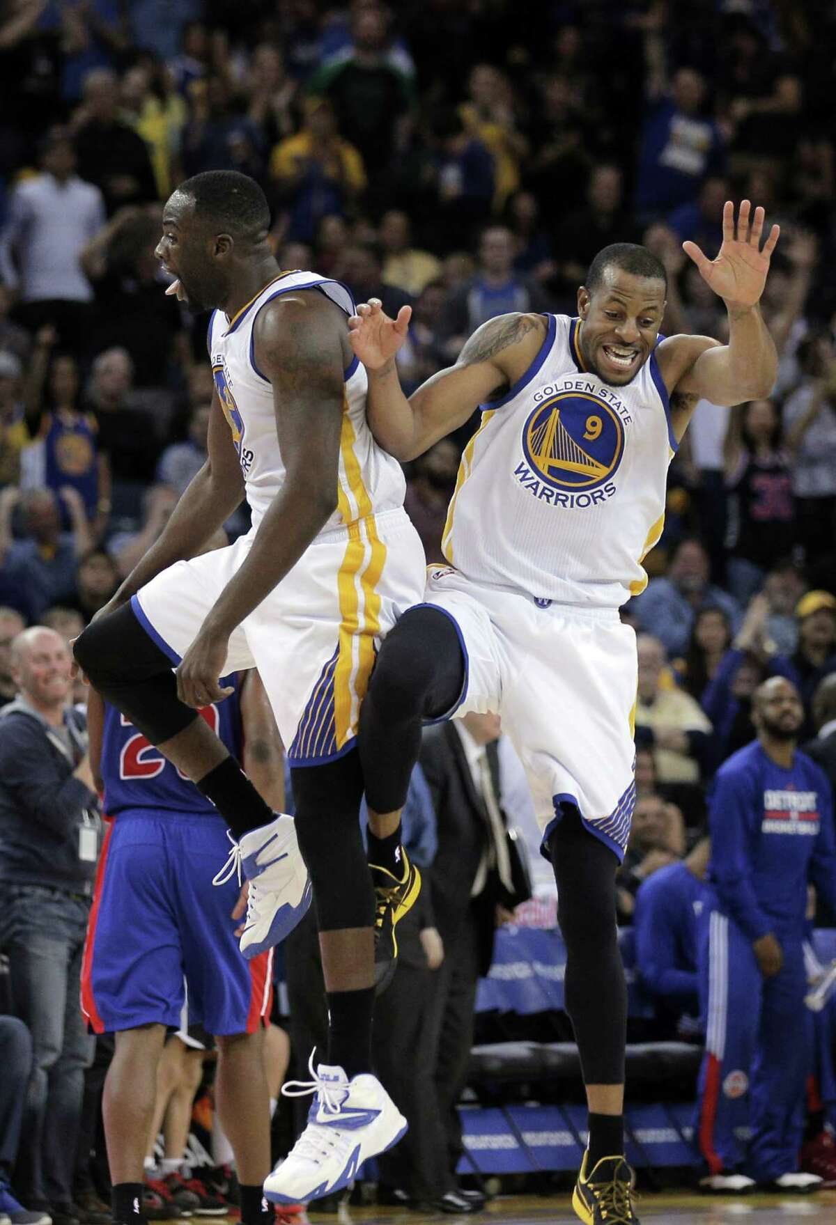 Andre Iguodala (9) and Draymond Green (23) celebrate Iguodala's fourth quarter dunk. The Golden State Warriors played the Detroit Pistons at Oracle Arena in Oakland, Calif., on Wednesday, March 11, 2015.
