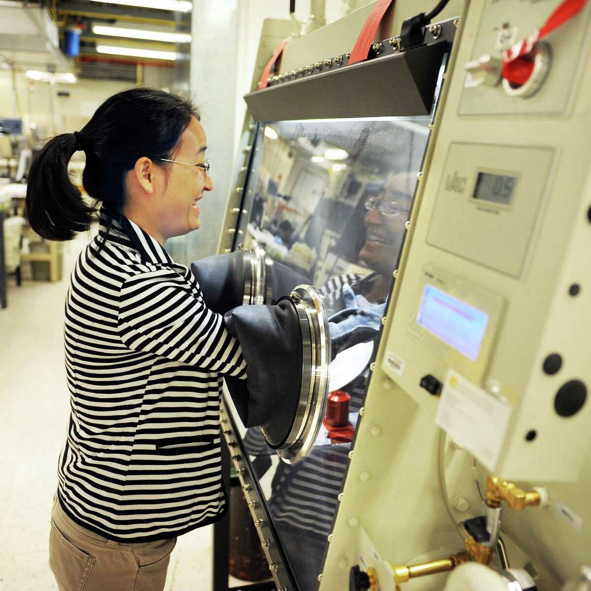 Research scientist Shasha Zhang works in the Glove Box, a controlled environment used for manufacturing BESS Tech's batteries in a SUNY Poly campus lab at CNSE Tuesday June 23, 2015 in Albany, NY. (John Carl D'Annibale / Times Union)