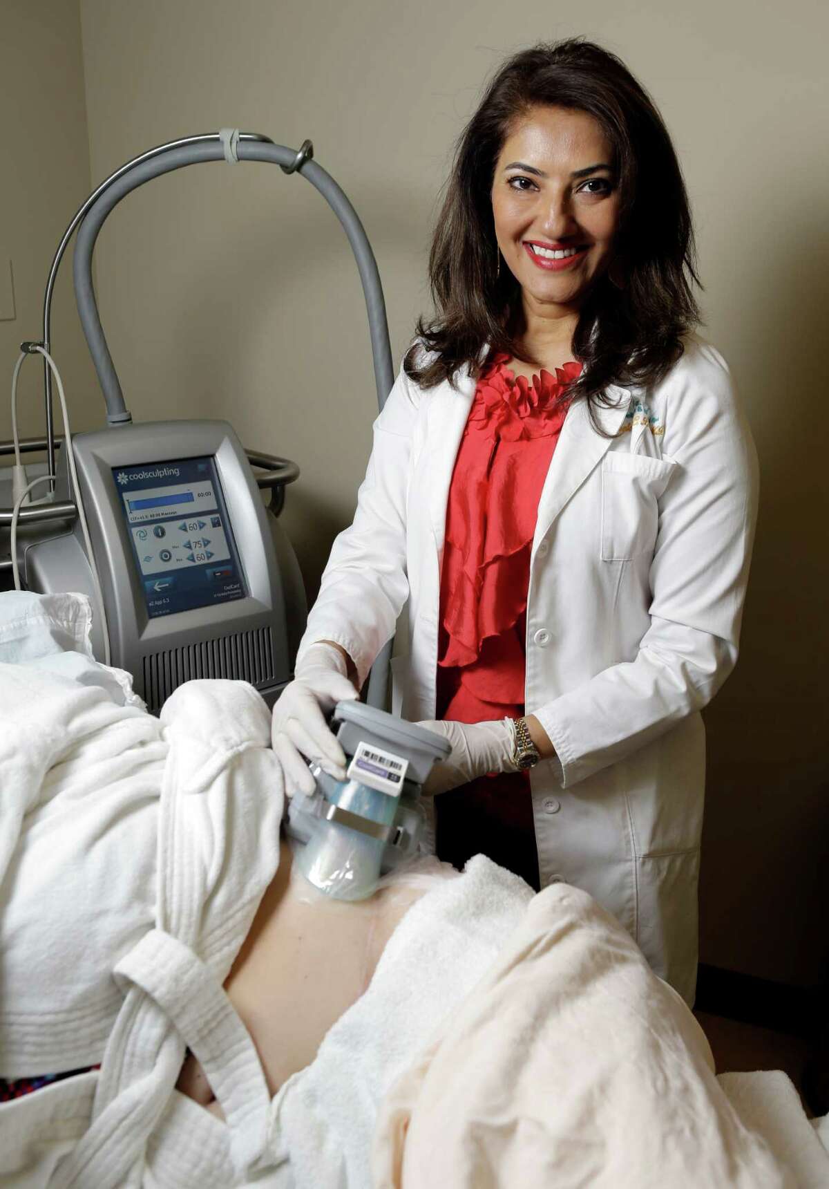 Dr. Shelena Lalji uses the CoolSculpting applicator to freeze a patient's fat cells. The procedure is designed to target exercise-resistant areas.