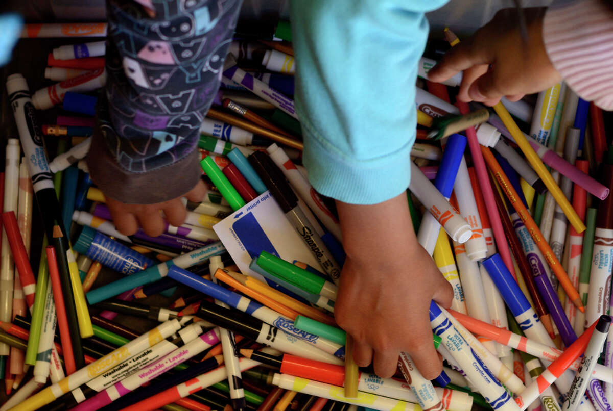 Hands grab for markers, pens and pencils inside the Tech Mobile that connects to people in underserved areas of S.F.