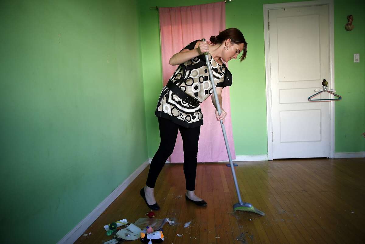 Kelly Dwyer sweeps her daughter's bedroom floor as she prepares to move out of her family's residence in San Francisco, Calif., on Wednesday, June 24, 2015.