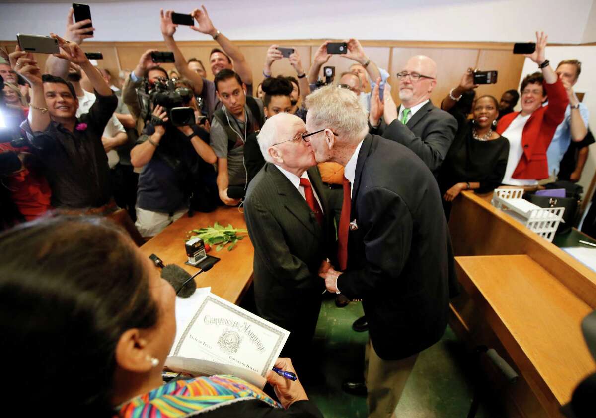 Judge Dennise Garcia, left front, watches as George Harris, center left, 82, and Jack Evans, center right, 85, kiss after being married by Judge Garcia Friday, June 26, 2015, in Dallas. Gay and lesbian Americans have the same right to marry as any other couples, the Supreme Court declared Friday in a historic ruling deciding one of the nation's most contentious and emotional legal questions. Celebrations and joyful weddings quickly followed in states where they had been forbidden.