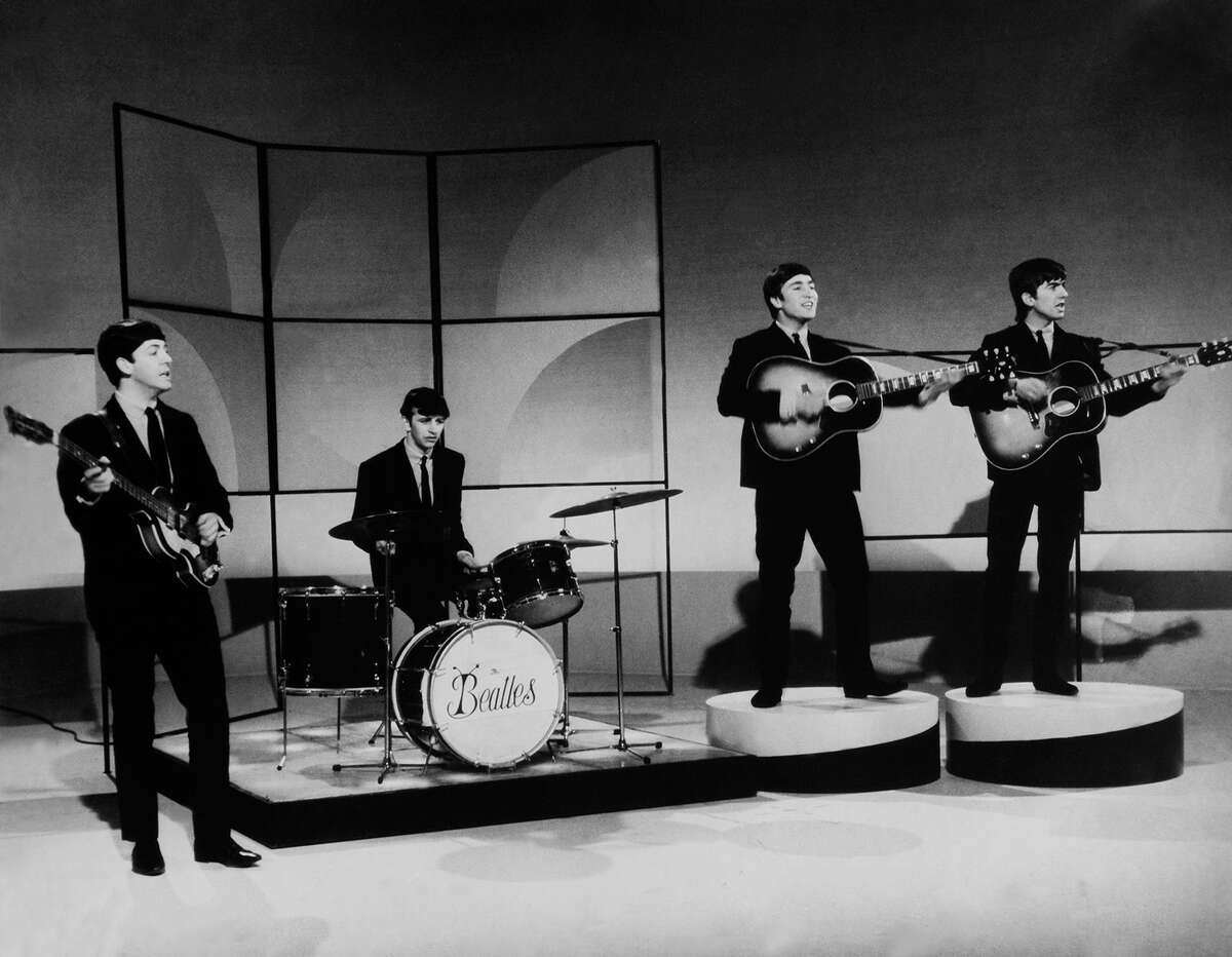 The Beatles early in their career, shortly after Ringo Starr joined the group. Note the short-lived "bug" band logo on Starr's drums.