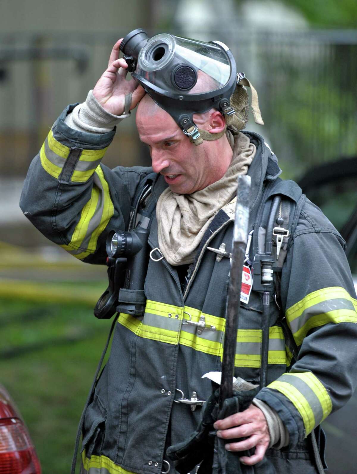 Danbury fire fighter Ken Monteavaro removes his mask after leaving a condominium, on Crows Nest Lane, in Danbury, Conn, where there was a fire on Saturday afternoon, June 27, 2015. The fire at Birchwood Condos began about 12:30 p.m. Asst. Deputy Chief Mark Omasta said.The blaze was contained to one unit and was quickly put under control.