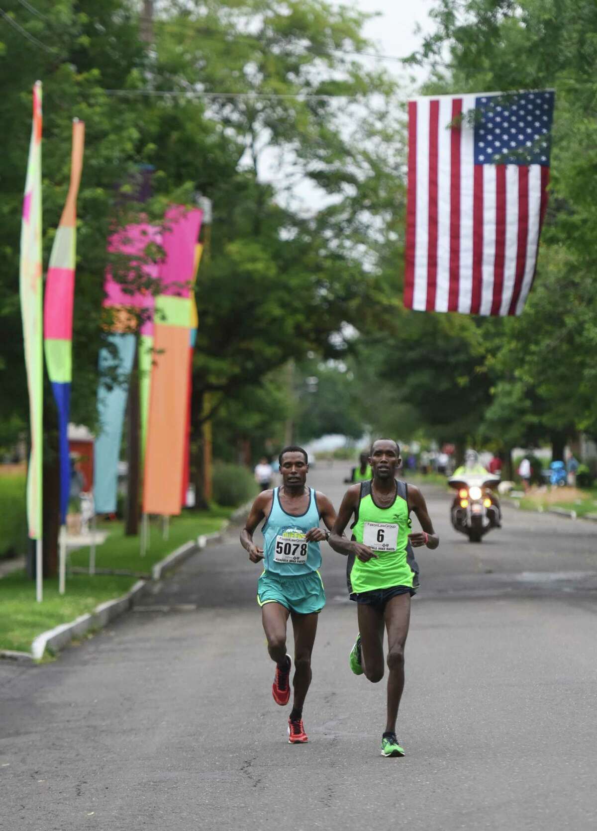 Ethiopia's Gosa Girma Tefera, left, battles Kenya's Josphat Kiptanui Too in the final miles of the Faxon Law Group Fairfield Half Marathon at Jennings Beach in Fairfield, Conn. Sunday, June 28, 2015. Gosa Girma Tefera, of Ethiopia, was the first place overall finisher with a time of 1:04:05 and Josphat Kiptanui Too finished in second with a time of 1:04:09. Etaferahu Temesgen, of Ethiopia, was the first female finisher with a time of 1:14:09.