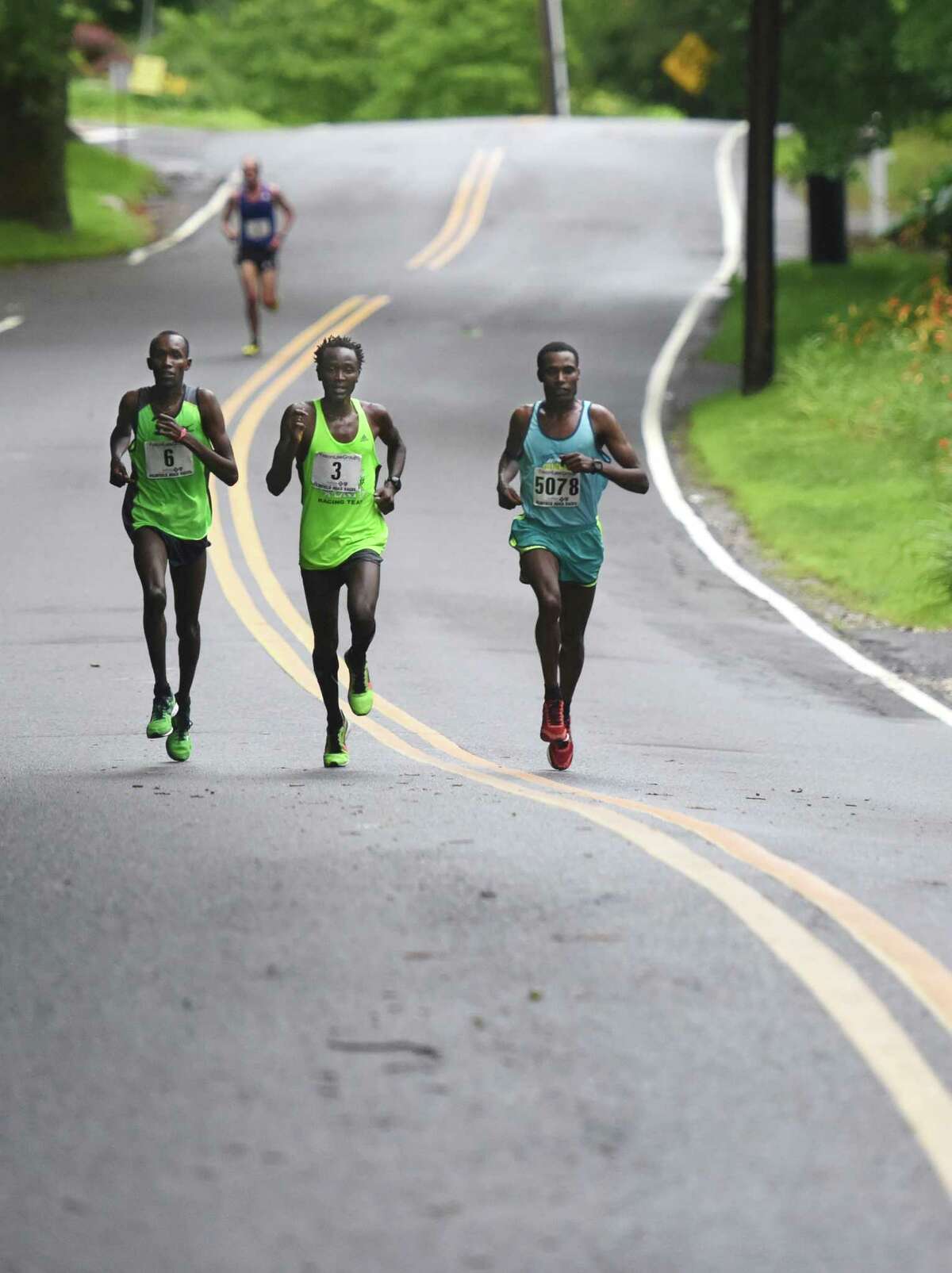 Second-place finisher Kenya's Josphat Kiptanui Too, left, third-place finisher Kenya's Eliud Ngetich, center, and race winner Ethiopia's Gosa Girma Tefera battle it out midway through the Faxon Law Group Fairfield Half Marathon at Jennings Beach in Fairfield, Conn. Sunday, June 28, 2015. Gosa Girma Tefera, of Ethiopia, was the first place overall finisher with a time of 1:04:05 and Etaferahu Temesgen, of Ethiopia, was the first female finisher with a time of 1:14:09.