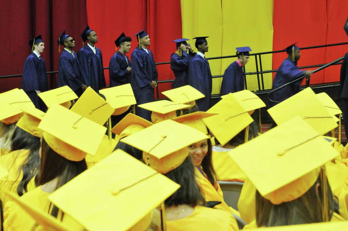 A group of boys make their way onto the stage to receive their diploma as girls look on at the Troy High School graduation at Hudson Valley Community College, on Sunday, June 28, 2015, in Troy, N.Y. (Paul Buckowski / Times Union)