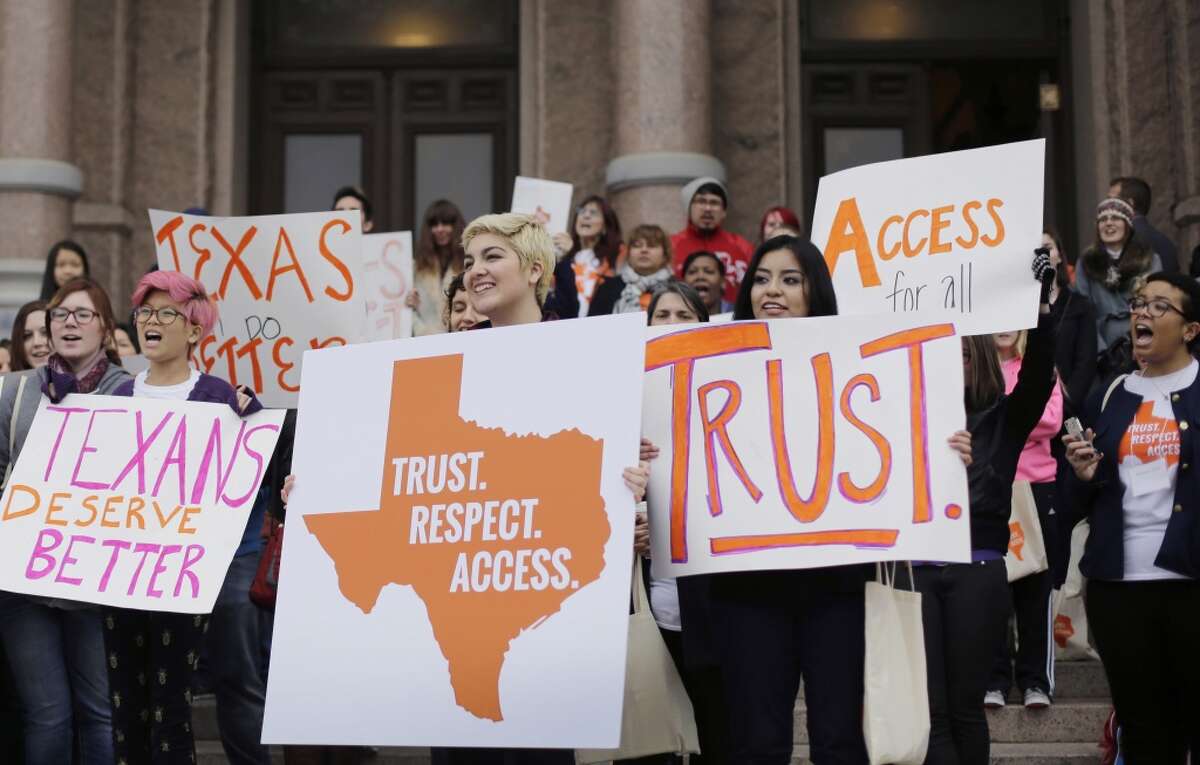 Estudiantes universitarios y partidarios del derecho al aborto sostienen pancartas durante una manifestación en febrero de 2015 en el Capitolio de Texas.