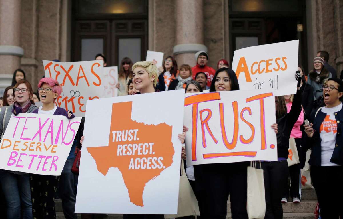 FILE - In this Feb. 26, 2015 file photo, college students and abortion rights activists hold signs during a rally on the steps of the Texas Capitol, in Austin, Texas. The Supreme Court refused on Monday, June 29, 2015, to allow Texas to enforce restrictions that would force 10 abortion clinics to close. (AP Photo/Eric Gay, File)