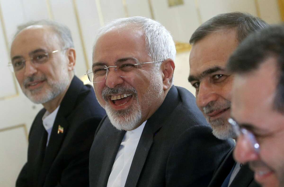 Iranian Foreign Minister Javad Zarif laughs during a meeting with U.S. Secretary of State John Kerry at a hotel in Vienna, Austria, Tuesday June 30, 2015. Pushing past a deadline, world powers and Iran extended negotiations for a comprehensive nuclear agreement by a week on Tuesday as the U.N. nuclear agency prepared to announce Tehran had met a key condition.