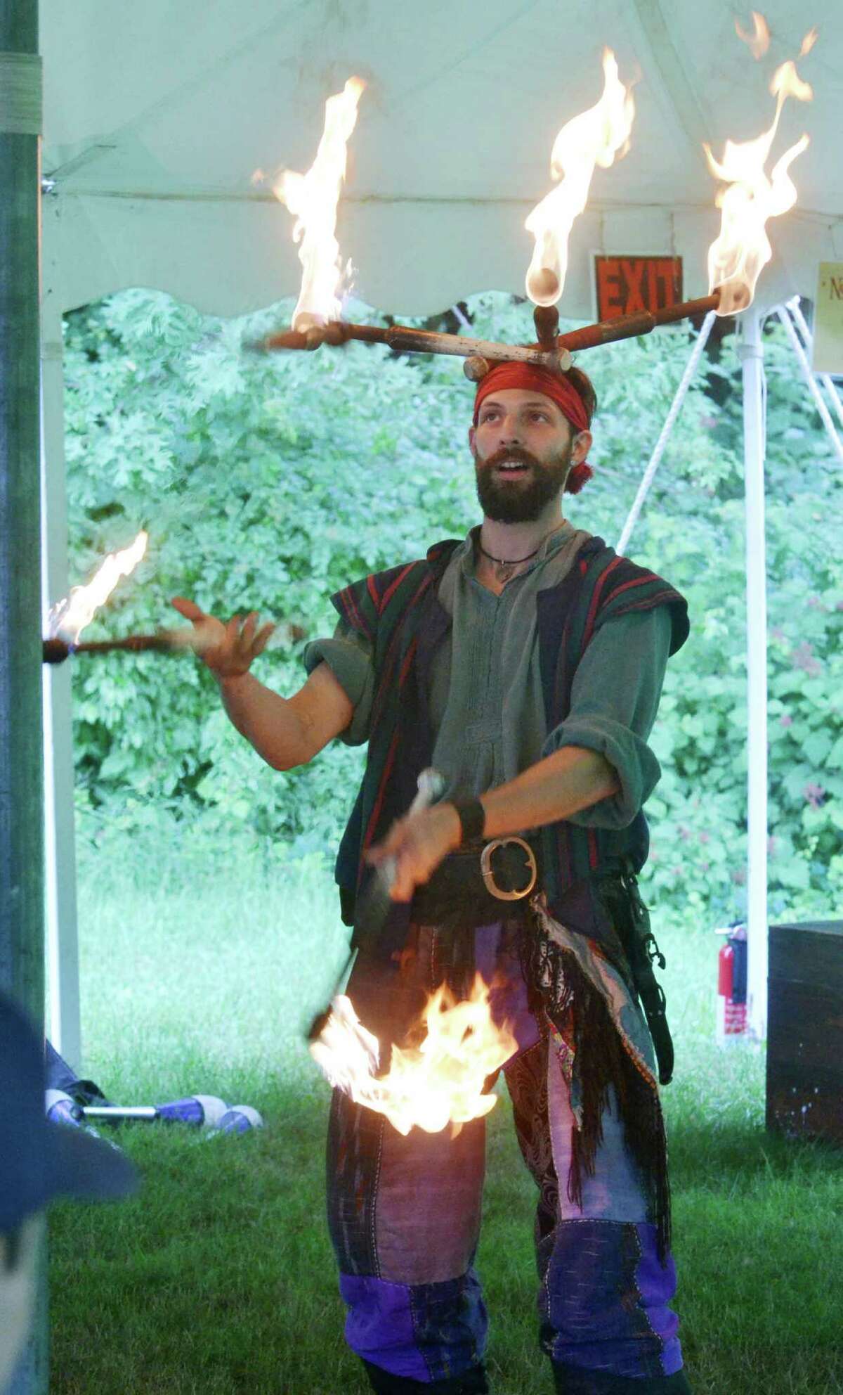Chris Abbot, from South Plainville, N.J., balances torches on his head while simultaneously jugging fire at the Midsummer Fantasy Reinassance Faire at Warsaw Park in Ansonia, Conn. on June 28, 2015. The last weekend to visit the faire is July 4-5, 2015 from 11 a.m to 6:30 p.m.