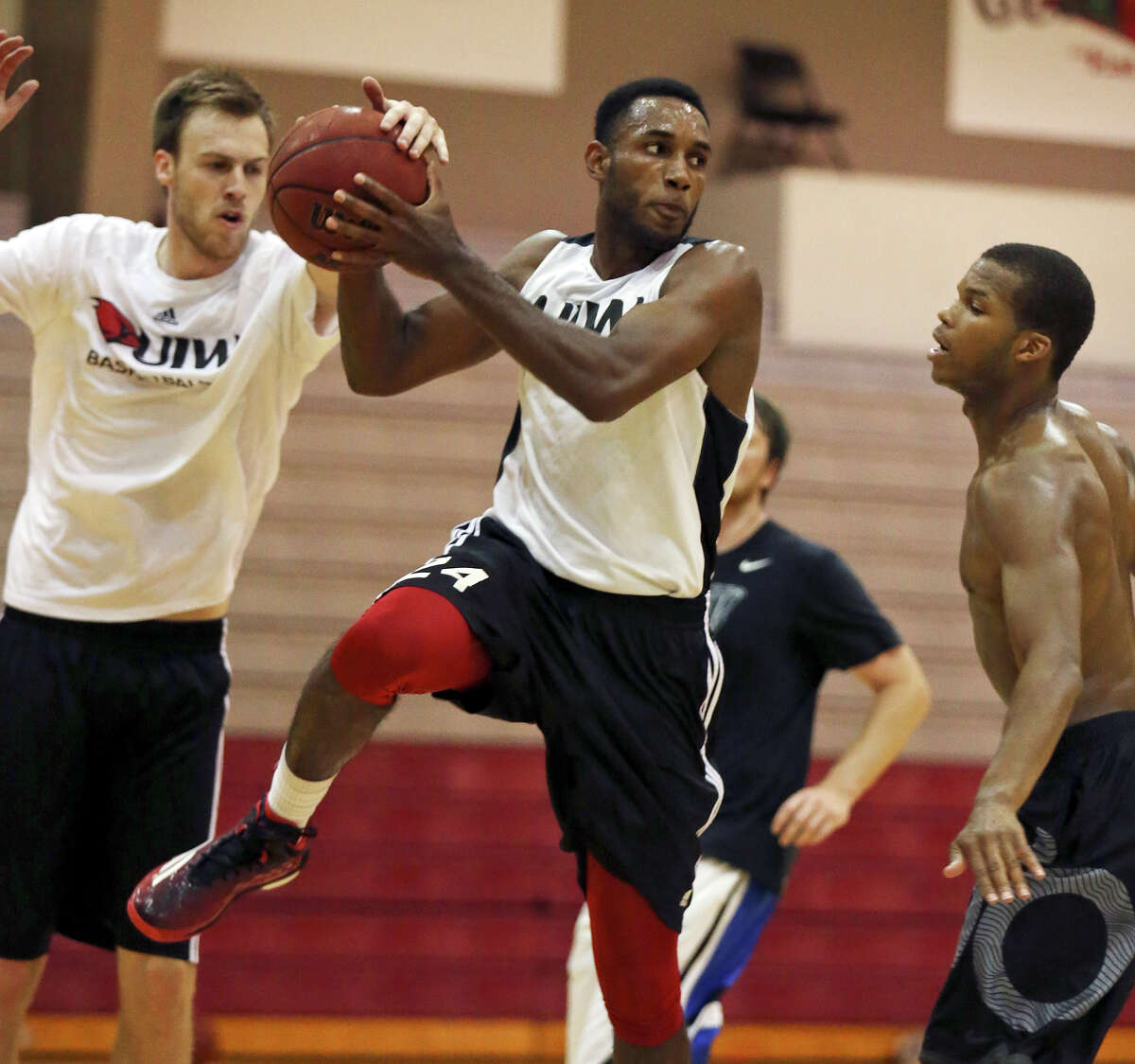 University of the Incarnate Word’s Phillip Johnson (center) looks to pass between University of the Incarnate Word’s Jerred Kite (left) and University of the Incarnate Word’s Shawn Johnson during a workout Monday June 29, 2015 at the McDermott Center.