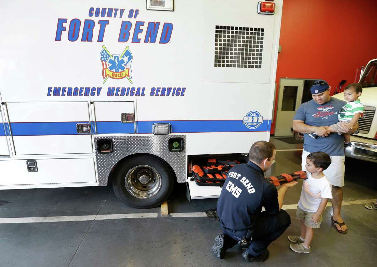 EMT Jose Diaz visits with 4-year-old Phillip Fong III, as his dad, Phillip Fong, holds his brother, Williams Fong, 1, while they tour the Stafford Fire Station No. 3, 11803 Kirkwood Road, Tuesday, June 30, 2015, in Meadows Place. Fort Bend County EMS relocated the Medic 3 ambulance to the fire station in the city of Meadows Place for better response in the growing area.