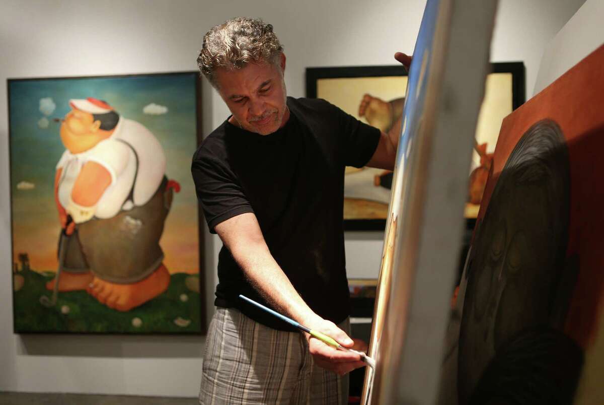 Artist Alberto Godoy works on a new art piece in his Houston studio on Wednesday, July 1, 2015, in Houston. Godoy's art work depicts Cuban life emotions are high right now as the U.S. announces opening embassy in Havana.