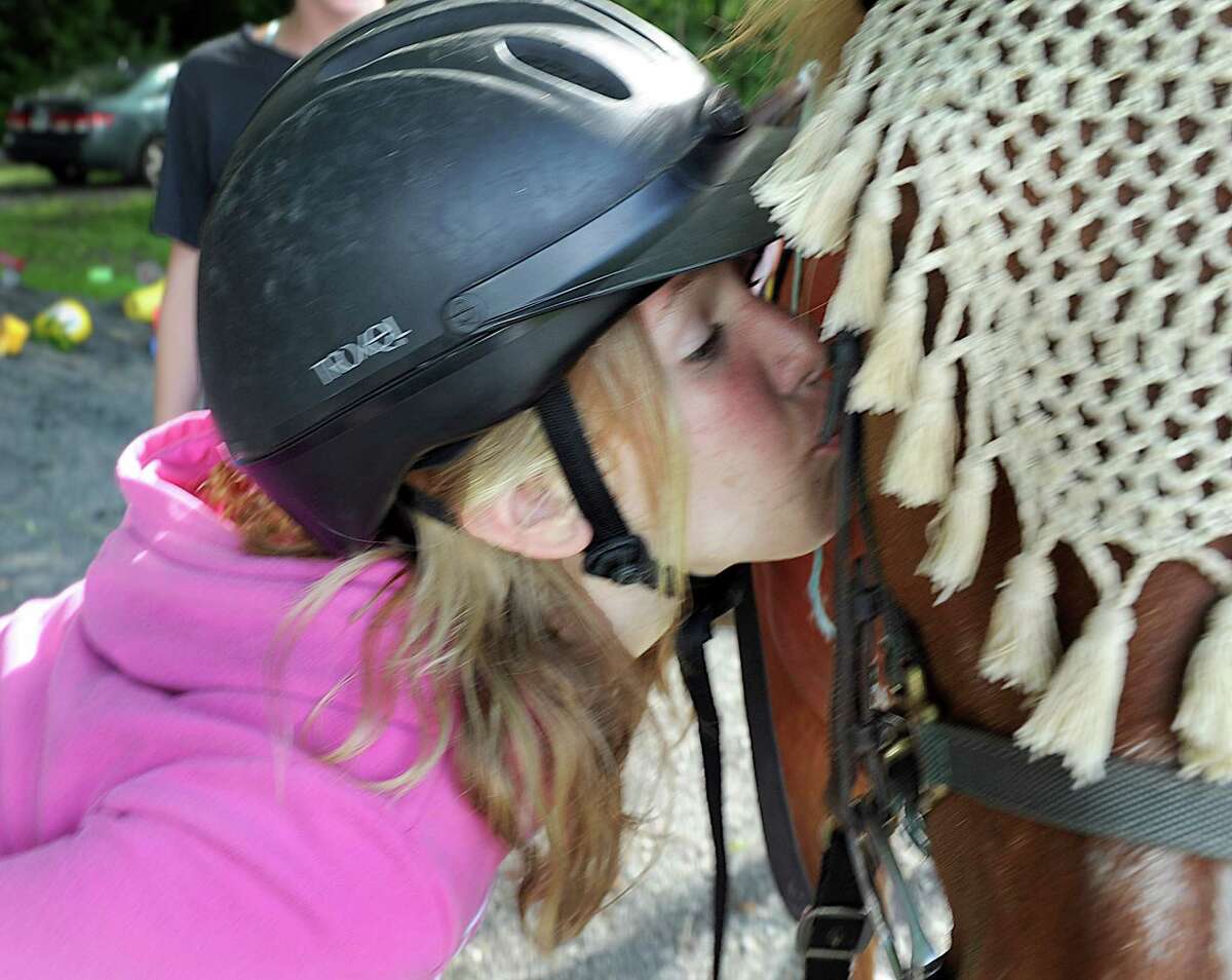 Gina Galligan, 11, of New Milford, plants a kiss on the horse she was riding during a session at Little Britches Therapeutic Riding in Roxbury.