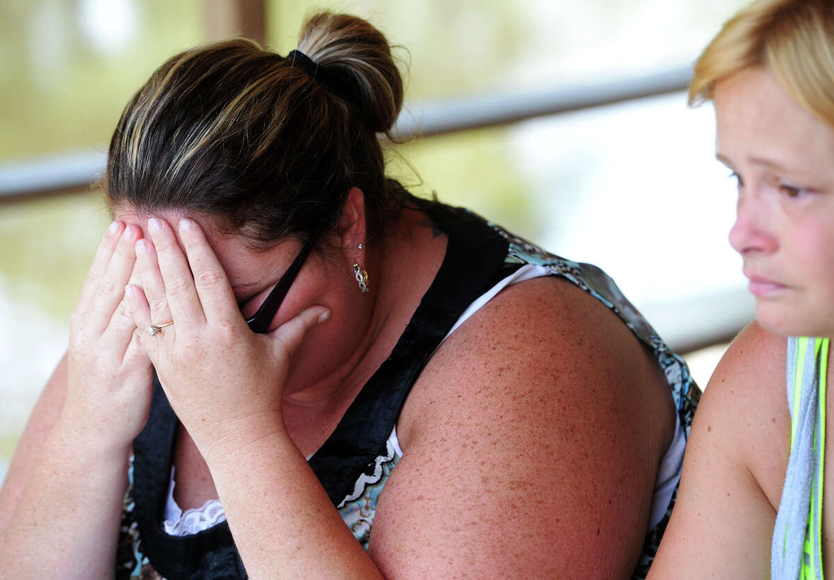 Angela Hoffpauir covers her face as she and Michelle Wright, right, recount the death of Tommie Woodward early Friday morning. Woodward, 28, was attacked and killed by an alligator while swimming in Adams Bayou at Burkart's Marina early Friday morning. The incident was the first fatal attack by an alligator in Texas in about 200 years. Photo taken Friday 7/3/15 Jake Daniels/The Enterprise