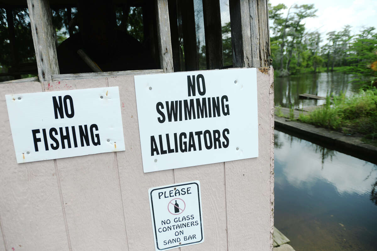 Signs warning patrons not to swim in Adams Bayou are seen at Burkart's Marina on Friday. Tommie Woodward, 28, was attacked and killed by an alligator while swimming in Adams Bayou at Burkart's Marina early Friday morning. The incident was the first fatal attack by an alligator in Texas in about 200 years. Photo taken Friday 7/3/15 Jake Daniels/The Enterprise