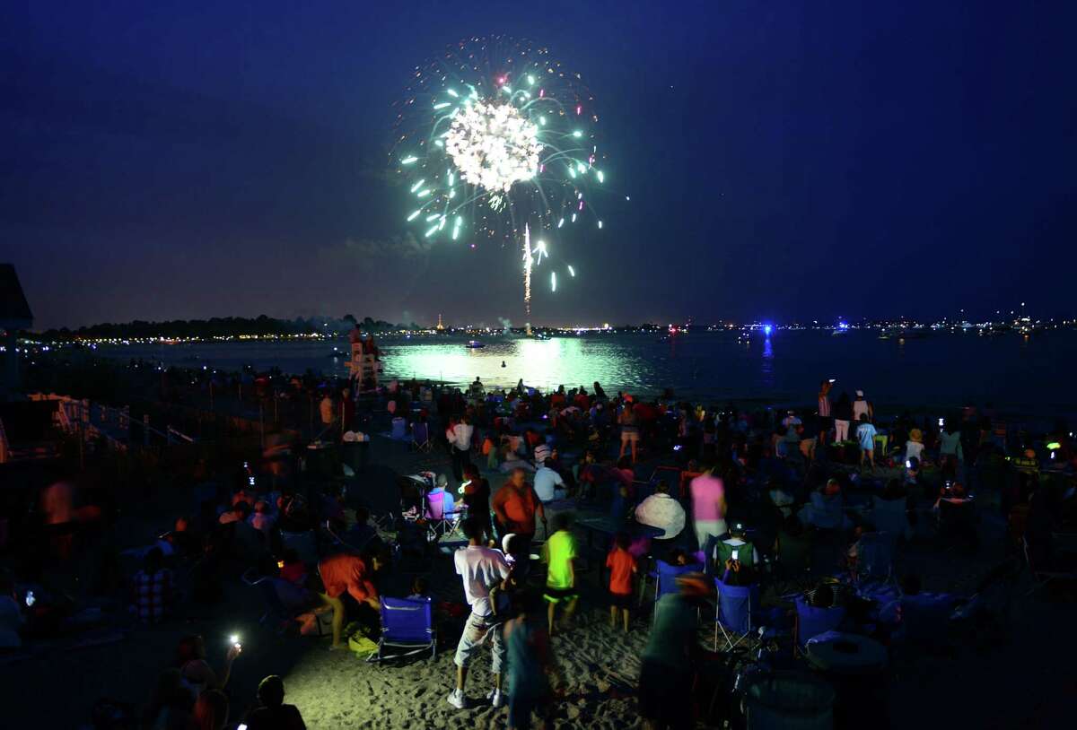 Hundreds of spectators watch the holiday fireworks display at Penfield and Jennings beaches in Fairfield on Friday.