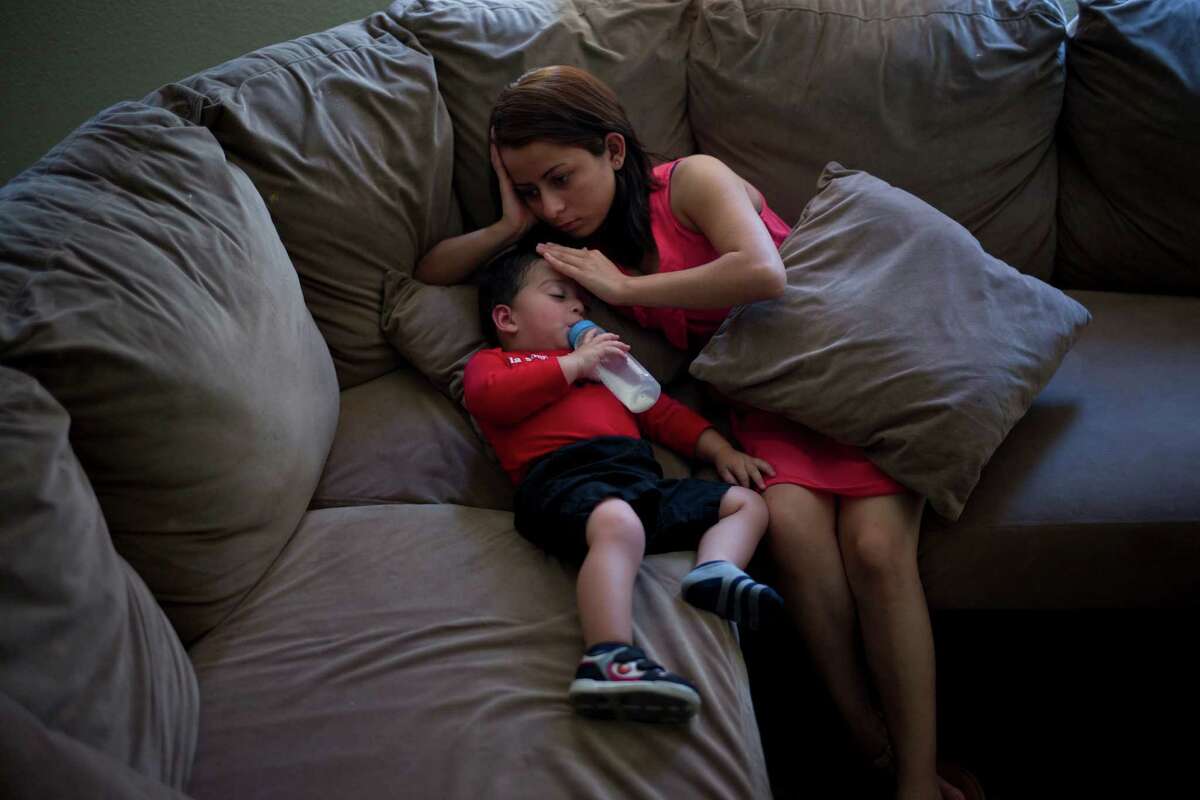 In this Monday, June 8, 2015 photo, 1-year-old Joshua Tinoco snuggles with his mother, Dunia Bueso, a 18-year-old Honduran who won the right to seek permanent residency under a U.S. program for abused and abandoned children, while taking a nap at their relative's home in Los Angeles. At a brief hearing, a government lawyer tells the teenage mother that her son is an immigration enforcement priority for the United States and should be sent back to his native Honduras even though she is being allowed to stay and seek a green card. (AP Photo/Jae C. Hong) ORG XMIT: CAJH205
