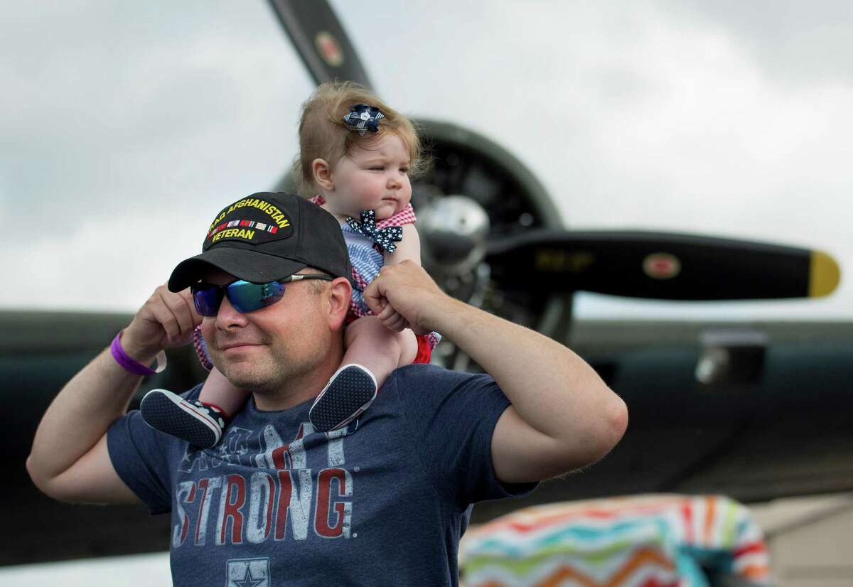 Army captain Tim Souza walks with his 7-month-old daughter, Emma, on his shoulders during the Commemorative Air Force Independence Day air show, Saturday, July 4, at Stinson Municipal Airport.