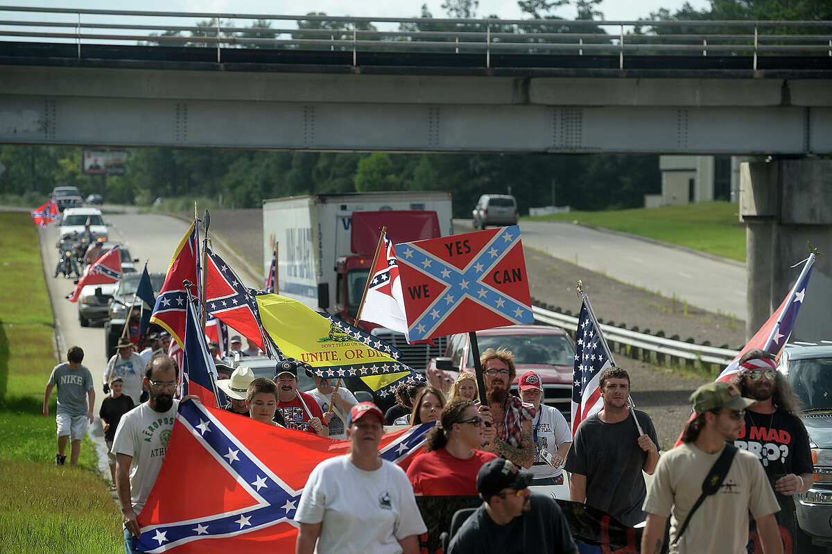 Supporters of the Confederate flag, including members of the regional chapters of Sons of Confederate Veterans, march up Highway 327 in Silsbee on Saturday. Organized by Ricky Stuart, the event, like a similar one at Gulfgate Mall, was intended to celebrate the pride in heritage associated with the flag, and comes in the wake of recent calls to ban the flag. ﻿
