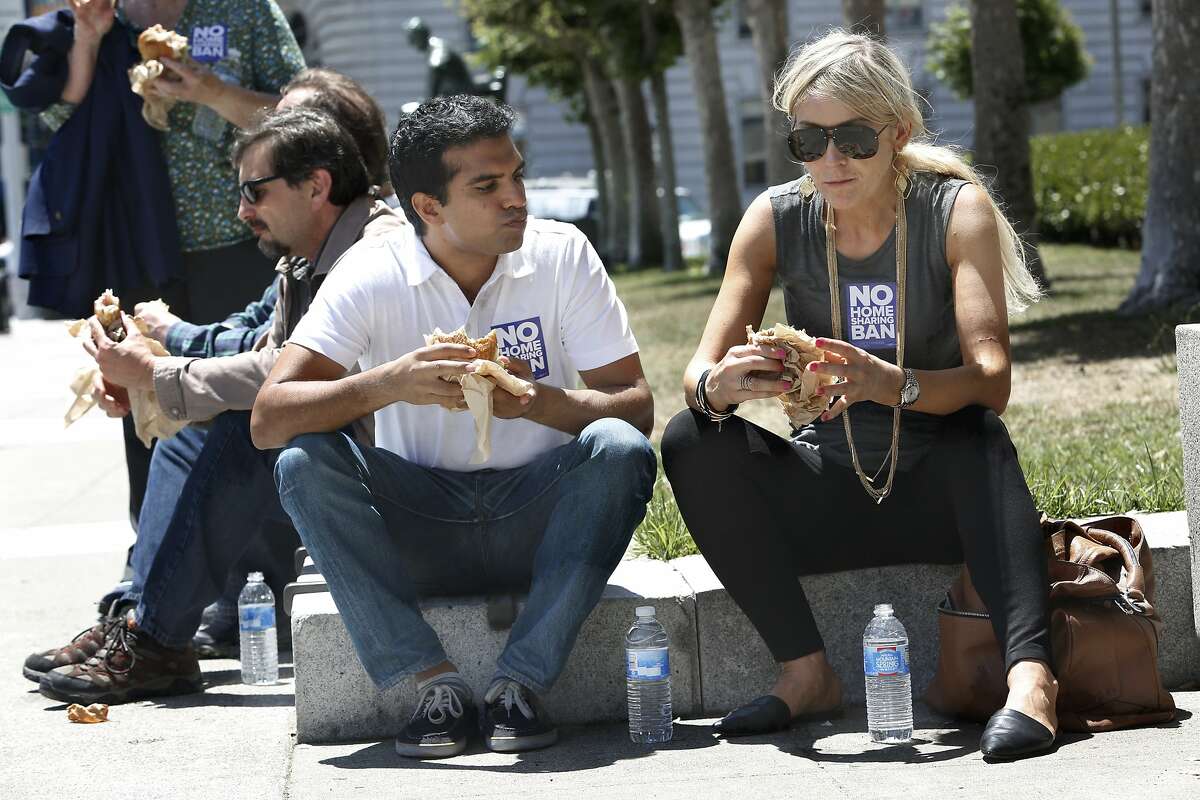 Timur Kahn (left) and Agnieszka Pilat (right) representing in a new group called "San Francisco for Everyone" have lunch next to city hall steps after rallying in San Francisco, Calif., on Monday, July 6, 2015. They rallied to protest the expected filing of signatures for a November ballot initiative that would clamp down on home sharing in private homes. Kahn shares a studio he lives in.