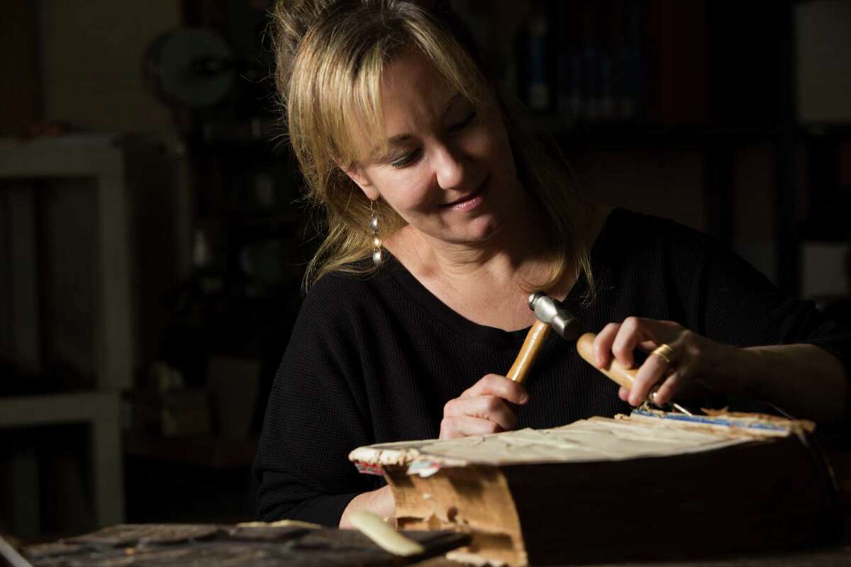 Deborah Karchmer owner of Bella Becho Book & Print Bindery removes the original spine of a 1800s Bible for restoration purposes. Thursday, June 18, 2015, in Houston. ( Marie D. De Jesus / Houston Chronicle )