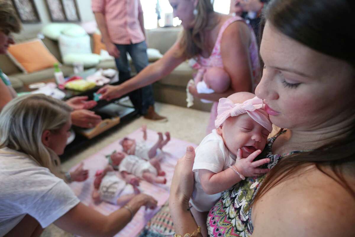 Danielle Busby carries daughter Ava Lane at home in League City, Texas, Monday, July 6, 2015. Ava Lane, the last of the first all-girl quintuplets born at Woman's Hospital of Texas, was released Monday after a three month stay in the neonatal intensive care unit, according to the Houston Chronicle. (Mayra Beltran/Houston Chronicle via AP) MANDATORY CREDIT