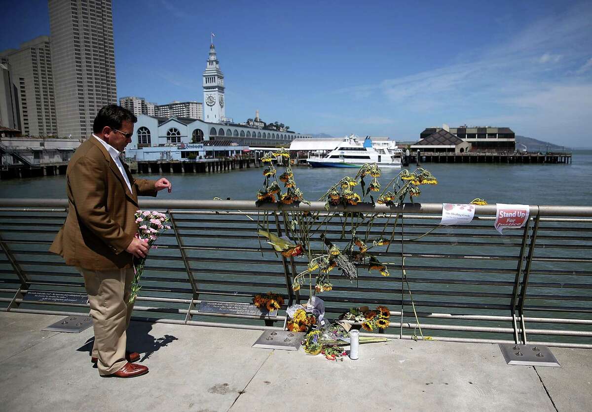 A well-wisher drops off flowers at the site where 32-year-old Kathryn Steinle was killed last week in San Francisco.