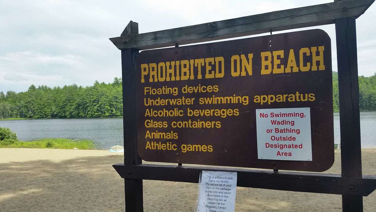 A sign at the empty beach along Fourth Lake at the Luzerne Campground in Lake Luzerne. Swimming at the beach is prohibited because the state has been unable to find a lifeguard. (Photo by Chris Churchill / Times Union)