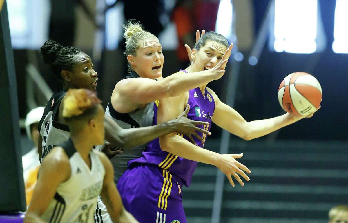 Los Angeles Sparks' Marianna Tolo (14) gets defensive pressure from Jayne Appel (32), Sophia Young-Malcolm (33) and Danielle Robinson (13) at the Freeman Coliseum on Wednesday, July 8, 2015. (Kin Man Hui/San Antonio Express-News)