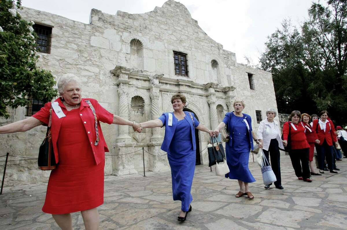 In this Oct. 5, 2006, file photo, members of the Daughters of the Republic of Texas join hands as they circle the Alamo in San Antonio as they mark their 100th anniversary of custodianship of the Alamo. A foundation that had planned to create a $400 million endowment to help the Alamo has disbanded within a year of announcing its plans. The foundation was technically separate from but endorsed by the Daughters of the Republic of Texas, a century-old group that oversees the historic Alamo grounds in downtown San Antonio. (AP Photo/Eric Gay, File)
