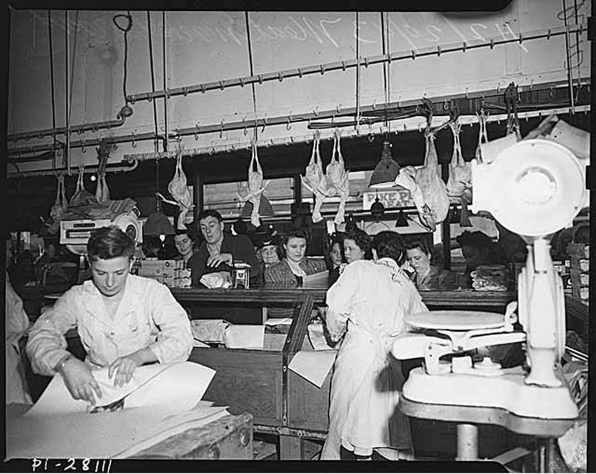 Butchers working at the Center Meat Co. at Pike Place Market, pictured in 1943. Meat was rationed at the time due to World War II.
