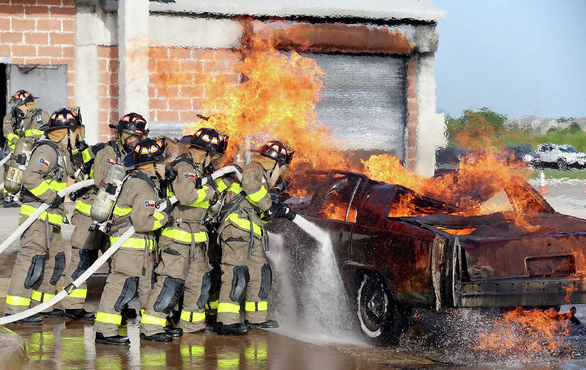 Members of the San Antonio Fire Department Cadet Class 2015 Alpha take part in a live fire demonstration part of the San Antonio Fire Department Cadet Family Night Thursday July 9, 2015 at the SAFD Training Academy. The 23 cadets, who spent the last 5-and-a-half-months training, will graduate on Friday becoming probationary firefighters for 6 months.