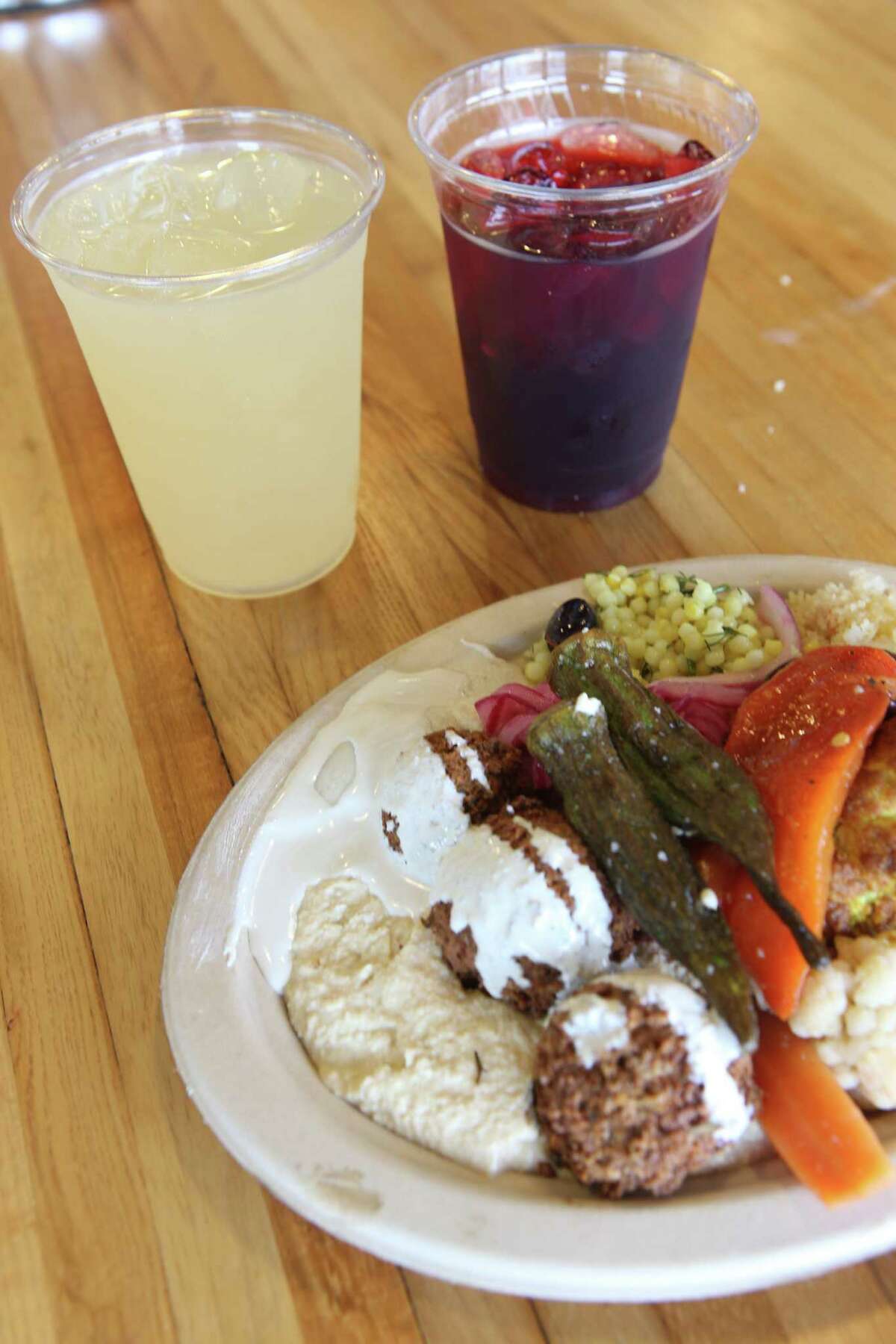 A falafel plate from Andrew Weissman's Moshe's Golden Falafel is seen with lemonade, left, and hibiscus tea in the background