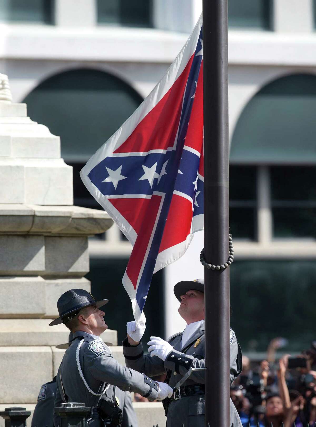 An honor guard from the South Carolina Highway patrol removes the Confederate battle flag from the Capitol grounds in Columbia, S.C., ending its 54-year presence there, on Friday, July 10, 2015. (AP Photo/John Bazemore)
