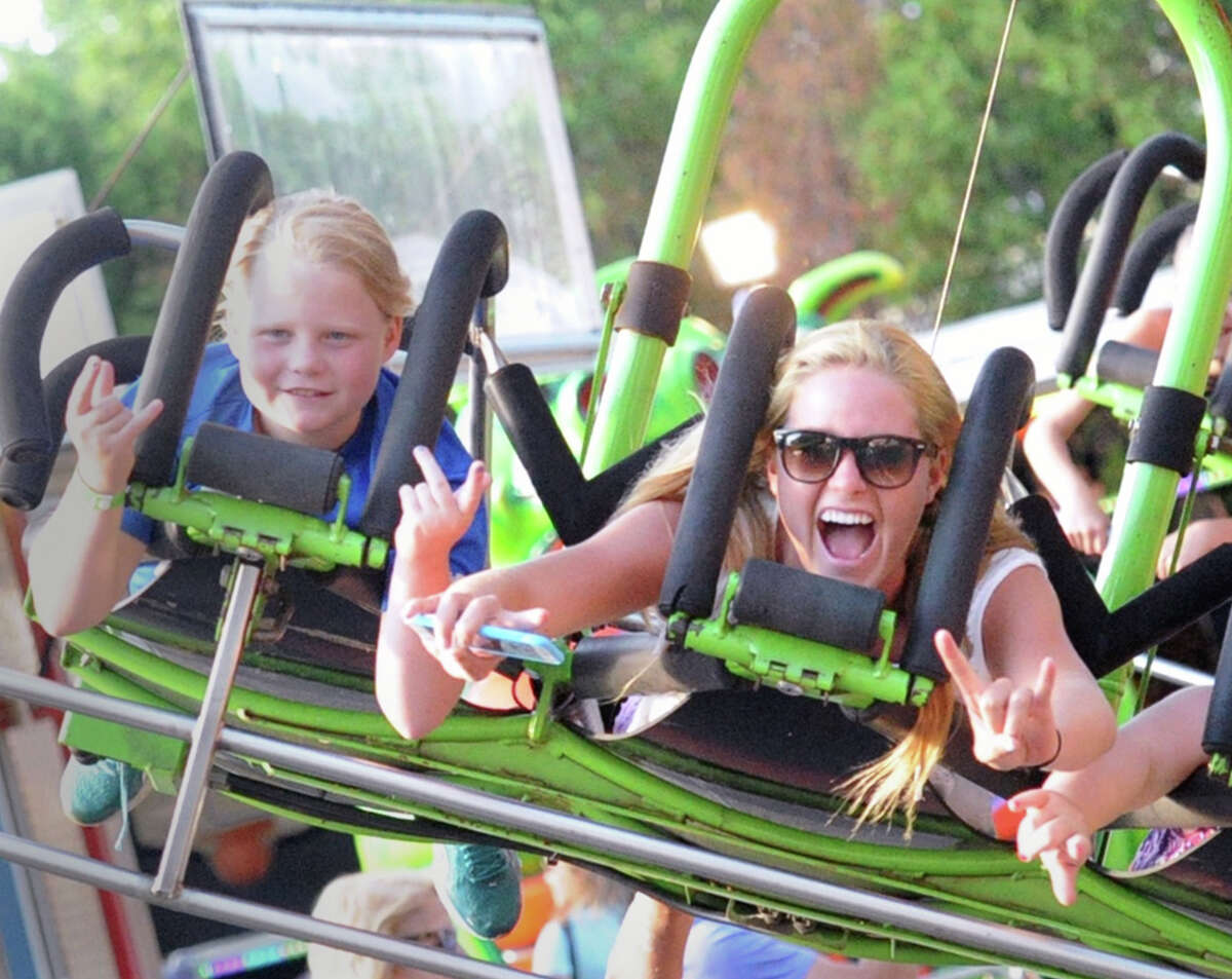 At right, Jenny Goggin of Geenwich screams while riding the Star Flyer during the St. Catherine of Siena Church annual Carnival of Fun at the church in the Riverside section of Greenwich, Conn., Friday night, July 10, 2015.