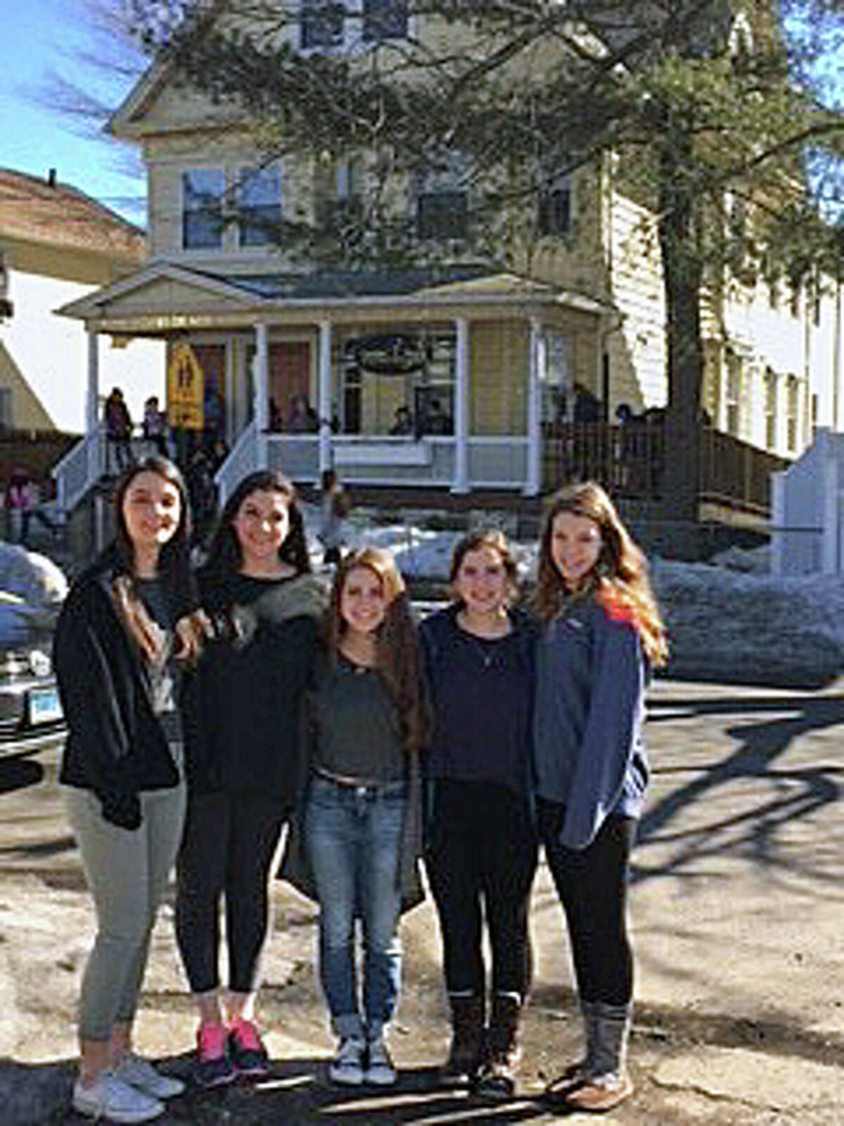 Members of the Caroline House Club, from Fairfield Ludlowe High School, stand outside the non-profit’s home in Bridgeport prior to a recent tutoring session.