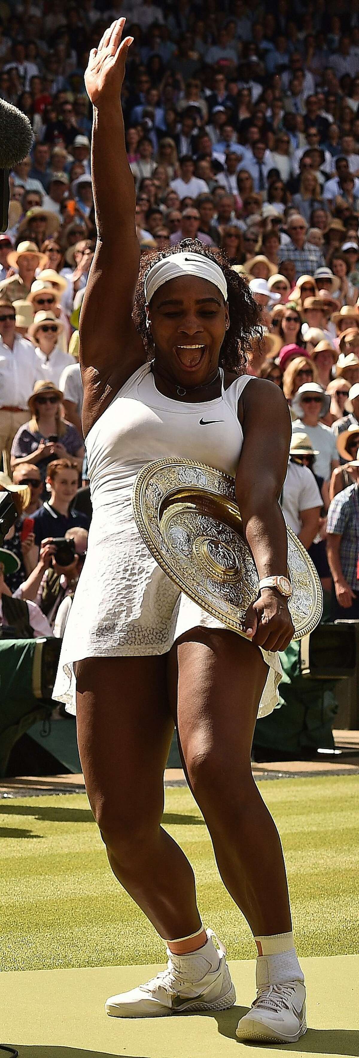 TOPSHOTS US player Serena Williams celebrates with the winner's trophy, the Venus Rosewater Dish, after her women's singles final victory over Spain's Garbine Muguruza on day twelve of the 2015 Wimbledon Championships at The All England Tennis Club in Wimbledon, southwest London, on July 11, 2015. Williams won 6-4, 6-4. RESTRICTED TO EDITORIAL USE -- AFP PHOTO / LEON NEALLEON NEAL/AFP/Getty Images